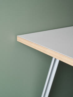 Corner detail of a rectangular wooden tabletop lined in light linoleum and mounted on a Beam aluminium table frame by Daniel Lorch for Faust Linoleum