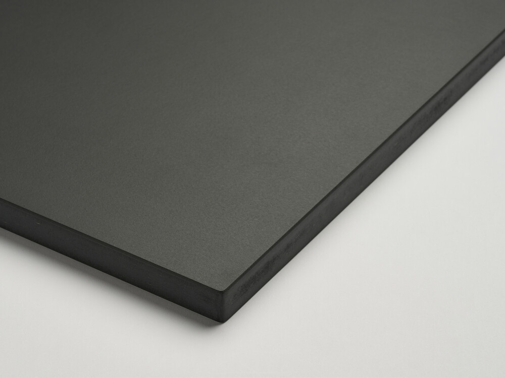 Detail of a Faust table top with matt linoleum surface in anthracite gray and beveled MDF edge in black.