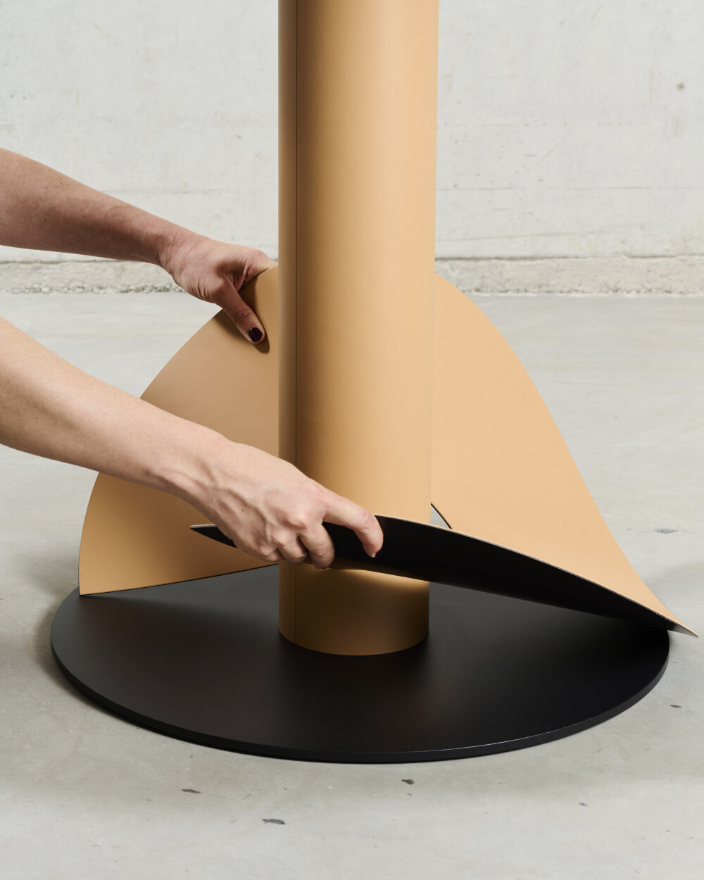 Removable magnetic linoleum cover being removed from the powder-coated steel base of the SPOT Bistro Table.