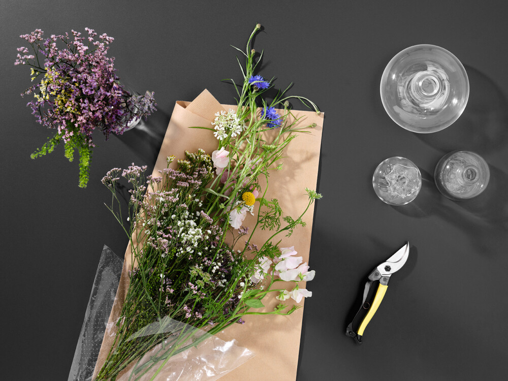 Faust Linoleumplatte in Anthrazitgrau – als dunkler Hintergrund für Blumen, Gartenschere und Vasen stilvoll inszeniert.