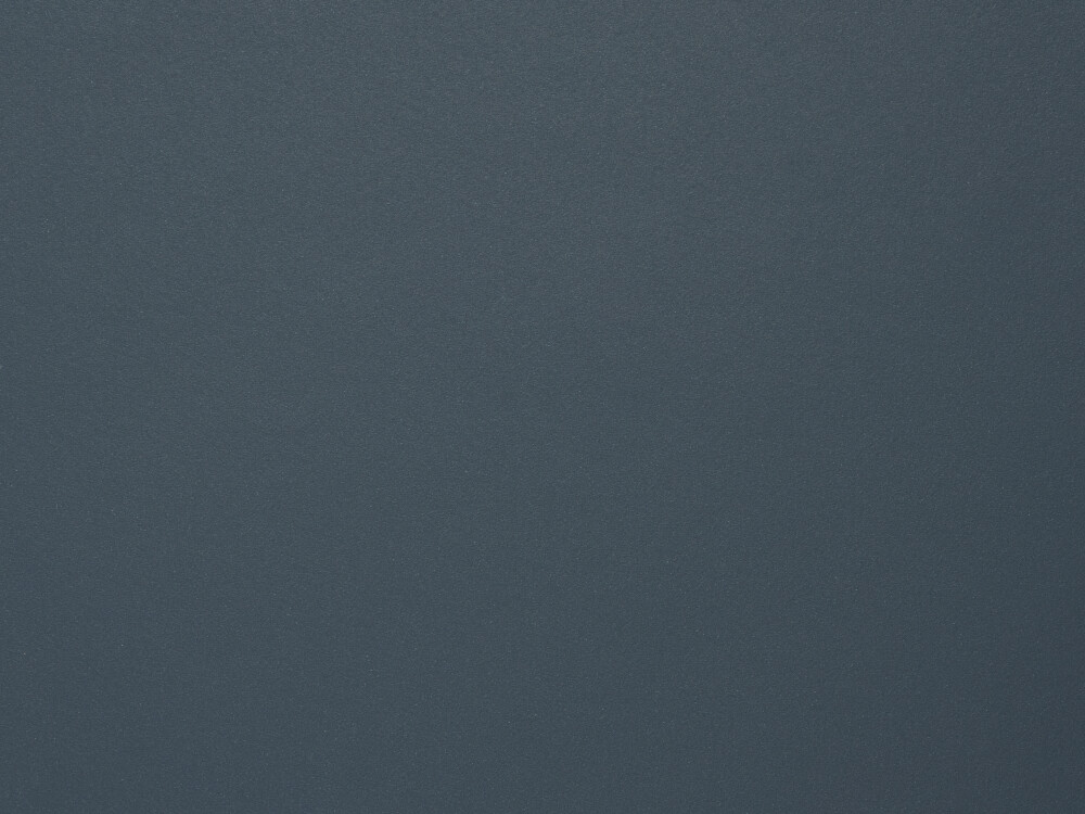 Linoleum-Oberfläche in Smokey Blue – matter, fein texturierter Belag in gedämpftem Dunkelblau, gezeigt als Faust-Materialdetail.