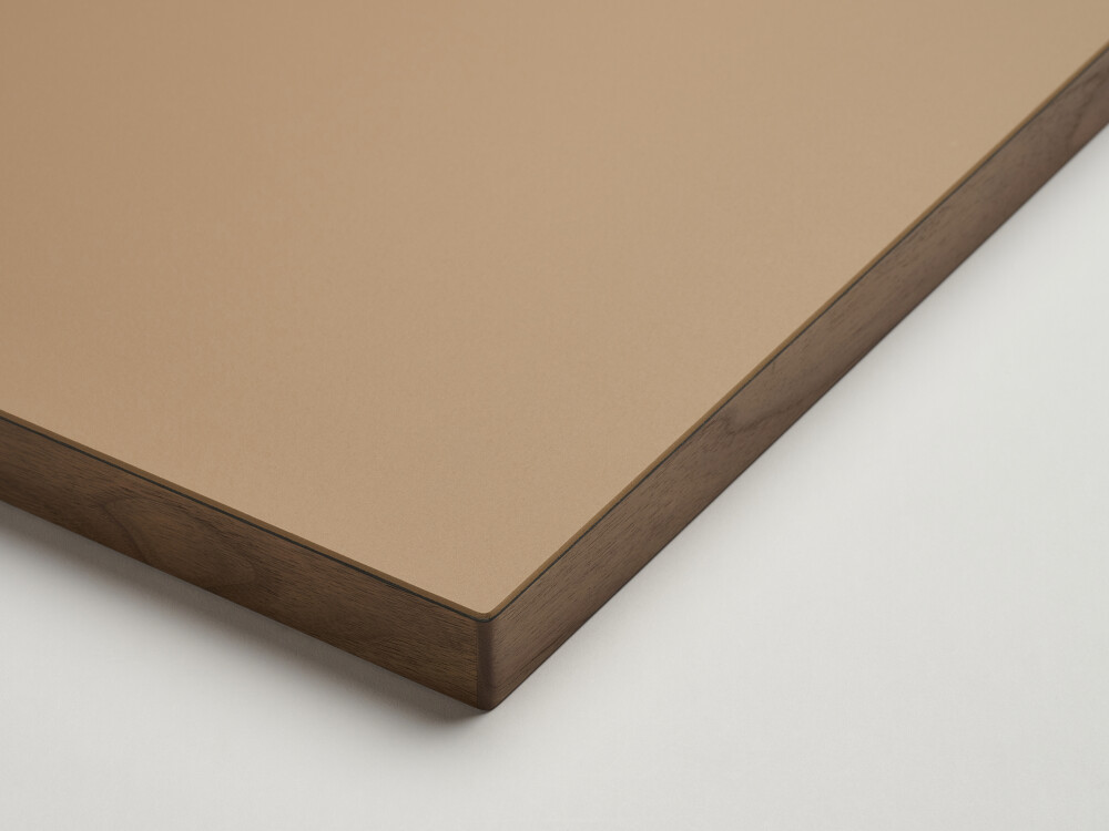 Table top from Faust with matt linoleum surface in brown (walnut) and solid walnut edge - close-up in the studio.