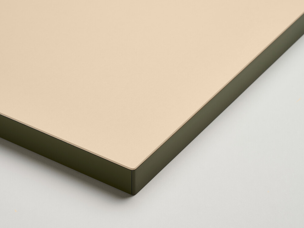 Matt linoleum table top from Faust in light beige (macadamia) with colored edge in olive - detailed view in the studio.