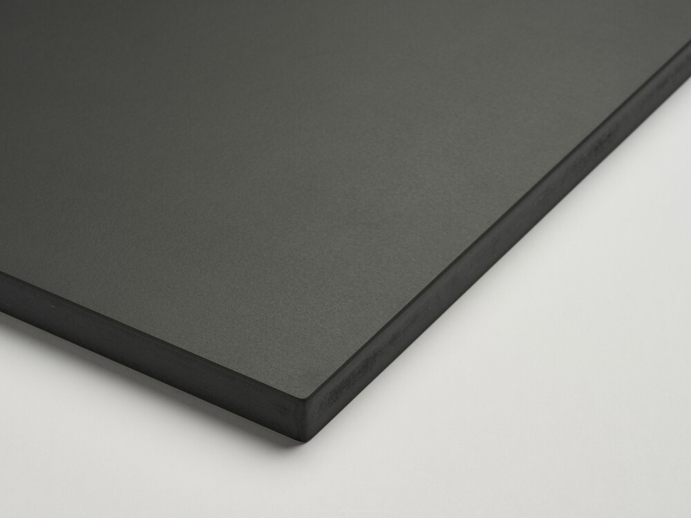 Detail of a Faust table top with matt linoleum surface in anthracite gray and beveled MDF edge in black.