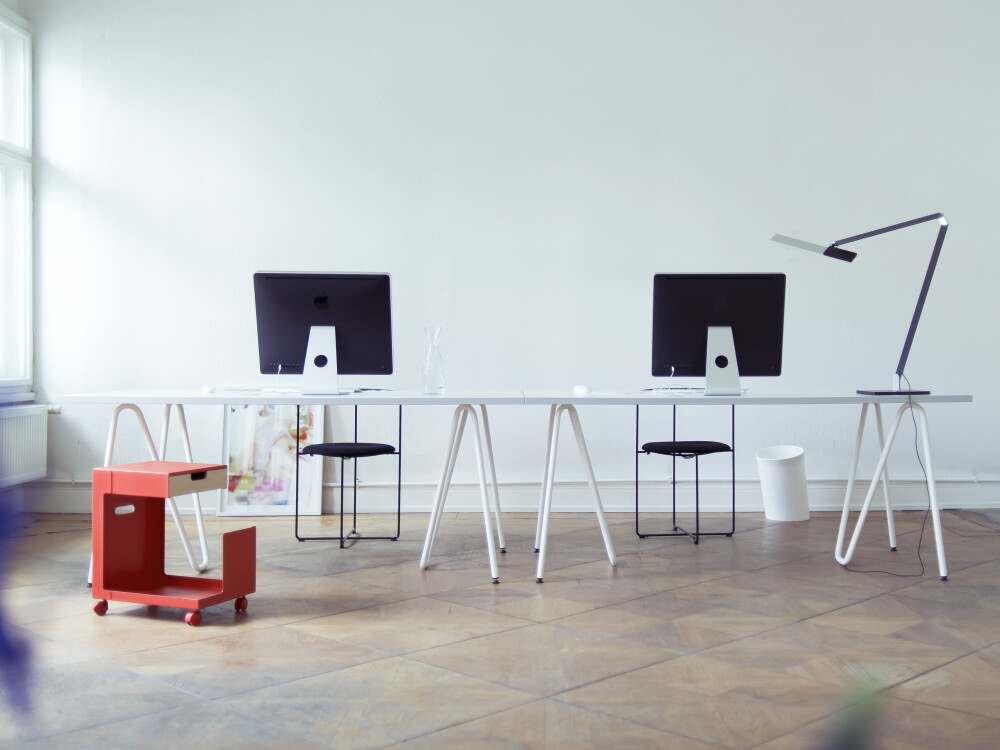 Minimalist workspace with white Sinus table trestles by Daniel Lorch and white-coloured tabletop.