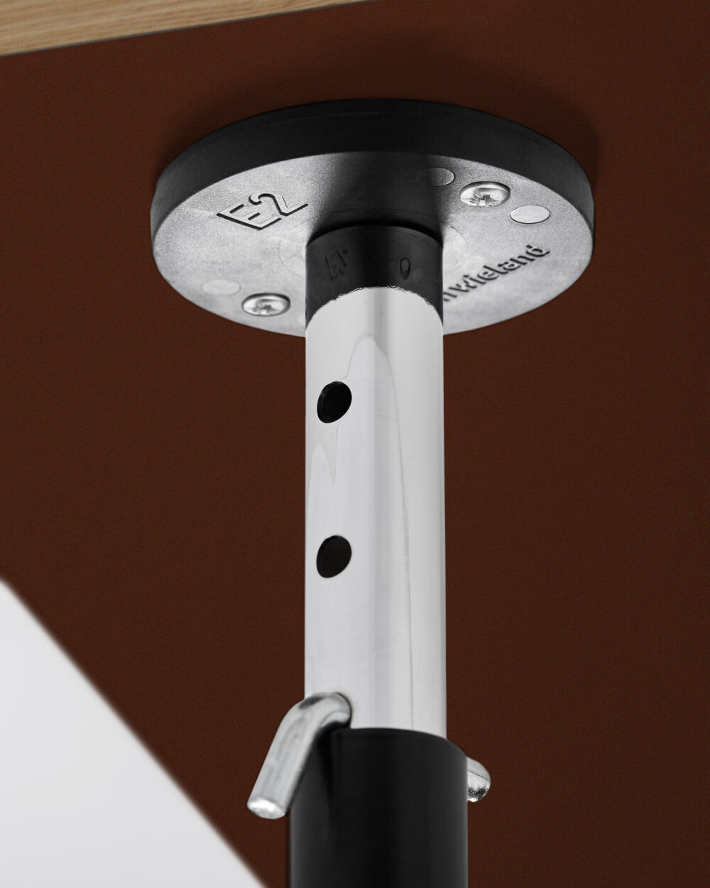 Plattenträger am E2 Gestell, stabilisiert und schützt eine dunkelrote Linoleumplatte mit beidseitiger Beschichtung.