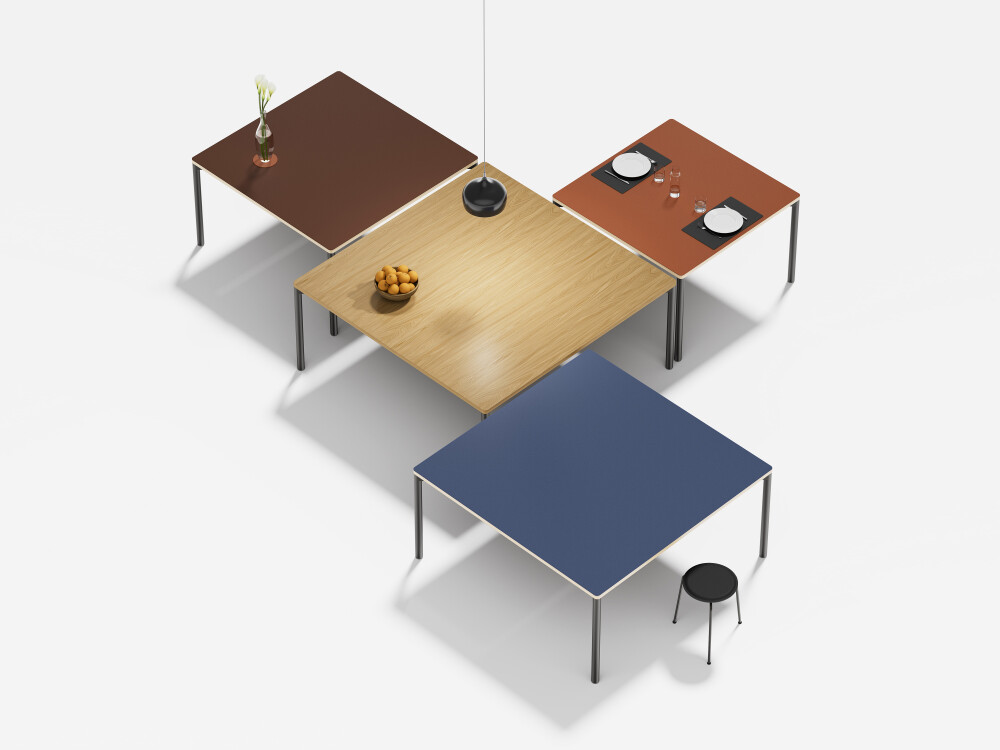 Four Outline desks from Faust in bold colours: table tops in burgundy, red, blue and wood veneer.