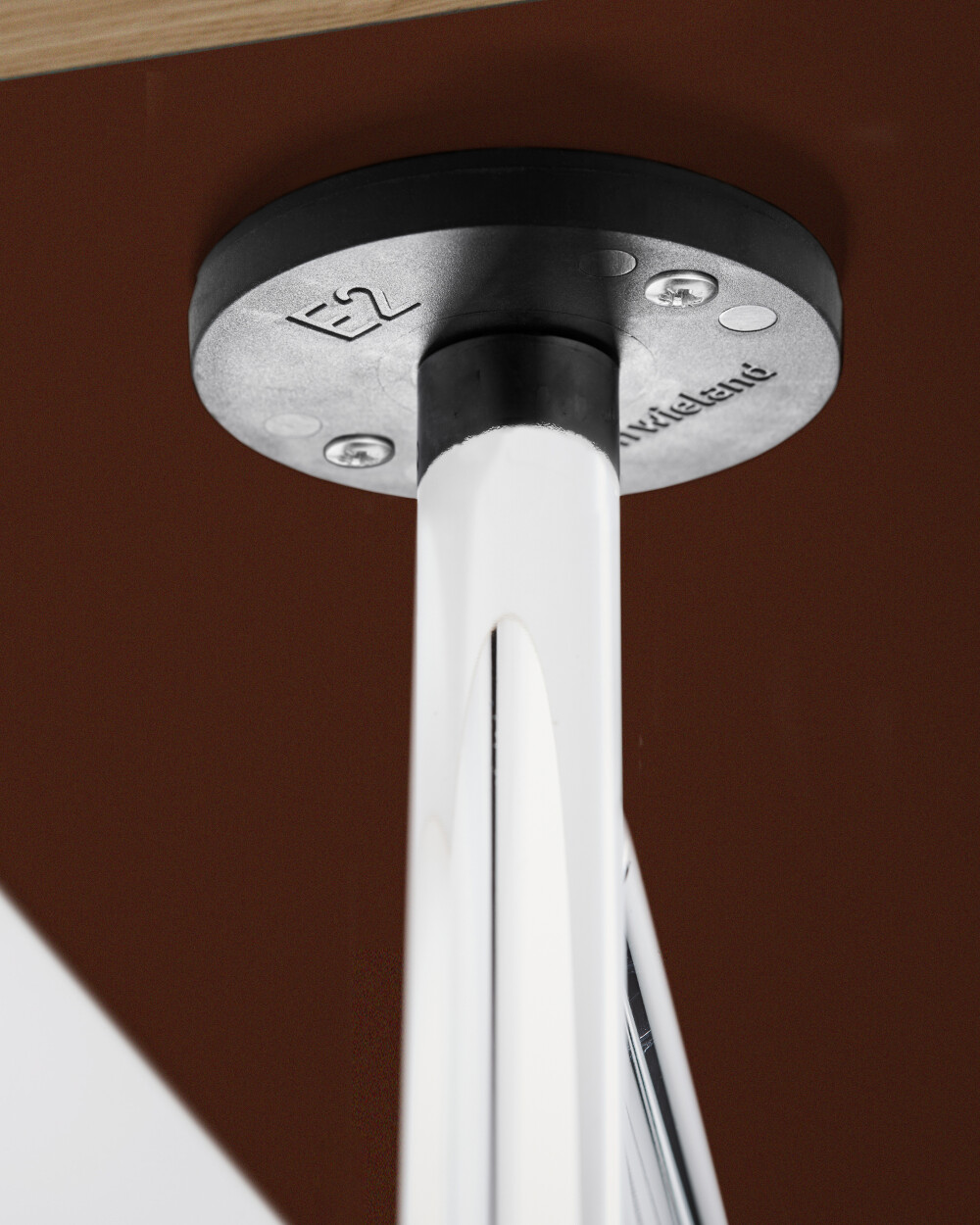 Close-up of a screwed E2 panel holder on a paper-coated table, mounted on a metal E2 frame.